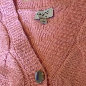 A small pink top with buttons going down it. Never worn. In good condition.